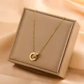 Close-up of 18k gold plated titanium steel necklace with Roman numeral ring pendant - Interlocking Roman Numerals Double Ring (86012)