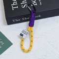 Close-up of colorful braided phone lanyard with yellow mesh sleeve and black carabiner. - Yellow And Purple Contrast Style (Huayang 1)