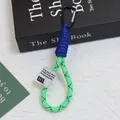 Macro view of neon green braided rope keychain featuring a blue paracord wrap detail - Neon Green And Blue Contrast Style (Huayang 3)