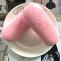 Close-up of two pink PU squishy faux French eclairs with red speckles on a white plate. - Croissant / Pink