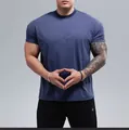 Detailweergave van een blauw fitness-T-shirt met korte mouwen op een gespierd model - Aqua