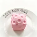 Pink cherry blossom cheese squishy toy for stress relief displayed on a white plate - Pink Cheese