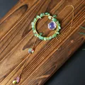 Detail of crystal suncatcher pendant with green stones and faceted glass beads on wood - Green Aventurine