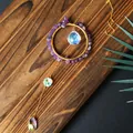Handmade crystal suncatcher with amethyst chips and iridescent glass prisms on wood - Amethyst