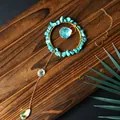 Handmade turquoise and iridescent crystal suncatcher pendant hanging on wood background - Turquoise
