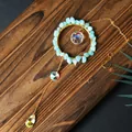 Close-up of blue stone wrapped ring and faceted crystal pendants on a suncatcher. - Aquamarine