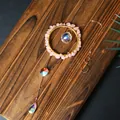 Close-up of a handmade crystal sun catcher featuring rose quartz and sparkling prisms - Rose Quartz