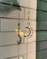 Détail d'un attrape-soleil en forme de croissant avec cristaux jaunes et prisme lumineux - Carillon de Lune en Citrine