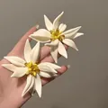 Detailed close-up showing the intricate resin petals of these white floral stud earrings - Stud Earrings (White-Yellow)