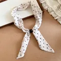 Primer plano de un pañuelo de seda blanco estilo francés con lunares negros y detalle de cuenta - Con Hebilla de Cuenta Negra / Lunares Blancos
