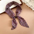Primer plano de una bufanda estrecha marrón estilo francés con estampado floral azul fino - Flor Verde
