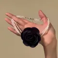 Detailed view of a multi-layer pearl necklace featuring a large black fabric rose - Black 3D Rose (HN13581) / Black