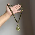 Détail d'un collier bohème avec pendentif goutte verte et chaîne en corde tressée - Style Pendentif Goutte d'Eau / Collier-Vert