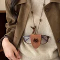 Nahaufnahme einer stylischen Brillenhalter-Halskette aus braunem Leder mit Katzenanhänger - Katze / Kaffeebraun