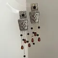 Close-up of vintage gold tassel earrings with intricate filigree and teardrop pendants - Vintage Tassel Style (HE35611-3) / Gold-Coffee-Black