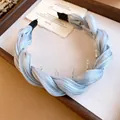 Gros plan d'un serre-tête en tissu tressé bleu clair avec des dents de préhension internes - Serre-Tête-Bleu