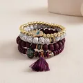 Close-up of four-piece stacked beaded bracelet set with Hamsa hand and purple tassel. - Four-Piece Set / Purple