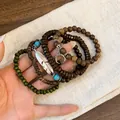 Detailed view of bohemian multilayer beaded bracelet set with feather and moon charms. - Feather Charm (14#) / Silver-Brown-Green