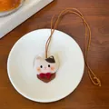 Detail van een schattige pluche kattenketting met lederen basis op een schoteltje - Ketting-Bruin-Wit