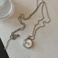 Detailansicht einer silbernen Quarzuhr-Halskette mit einer filigranen Box-Kette - Runde Halskettenuhr (WECIN) / Silber