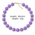 Gros plan d'un collier de perles en acrylique violet avec détails de poids et longueur - Violet