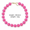 Vue détaillée du collier en perles acryliques roses mates avec fermoir doré et infos. - Rose rouge
