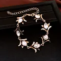 Gedetailleerde macro-opname van een antieke gouden bloemenarmband met traankristallen - Armband-Antiekgoud-Wit