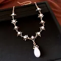 Detailopname van vintage bloemenketting met kristallen en grote witte waterdruppelparel - Ketting-Antiekgoud-Wit