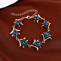Vintage goudkleurige bloemenarmband met blauwe traanvormige stenen op satijnen stof - Armband-Antiekgoud-Blauw