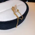Close-up of elegant gold butterfly ear cuff with zircon pavé and tassel chains - Butterfly Style (6#) / Single Piece / Gold