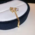 Detailed view of a gold-tone bow ear cuff featuring sparkling zircon stones and long chain tassels. - Bowknot Style (5#) / Single Piece / Gold