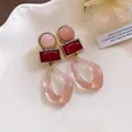 Retro geometric resin dangle earrings with pink and red accents on a white porcelain plate - Silver Earring Post Style / Pink and Red