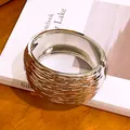 Detailed view of wide silver-colored cuff bracelet with rippled wrinkled texture - Silver