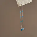 Nahaufnahme langer silberner Quastenohrringe mit eleganten blauen Zirkonia-Perlen - Lange Quasten Ohrstecker (HE35674) / Silber-Blau