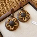 Primo piano di orecchini vintage in legno e resina con dettaglio fiore intrecciato. - Stile Retro Fiore in Corda Intrecciata (17# Perno in Argento)