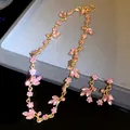 Close-up detail of the pink crystal leaf and flower necklace and earrings jewelry set - Necklace + Earrings Set / Gold-Pink