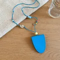 Close-up of blue leather glasses case necklace with cute shell and star charms - Necklace / Blue