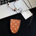 Detail view of brown polka dot leather pendant with heart charm on a beaded necklace - Brown