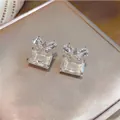 Detailed close-up of elegant butterfly zircon earrings with rectangular crystals. - Silver Post - Light Yellow