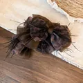 Detailed macro view of the leopard print fabric bow hair claw with feather accents - Bow Claw Clip / Brown Leopard