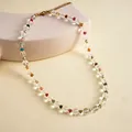 Detailed view of colorful beaded necklace featuring clear glass beads and gold clasp. - 8mm / White with Multicolored Stones