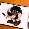 Gros plan sur un bijou de sac artisanal en forme de poupée originale à lunettes - Porte-clés poupée / Noir Blanc Marron Patchwork