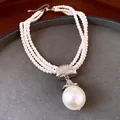 Detailopname van een Franse stijl meerrijige parelketting met een grote ronde parelhanger. - Zilver-Wit