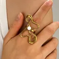 Niche design gold wavy abstract stainless steel ring featuring a white center pearl - Wave Abstract Butterfly Pearl (N-1109)