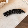 Detailopname van een elegante banaan haarklem van geplooide zwart-wit gestippelde stof - L / Bananenclip / Twist Clip - Zwart