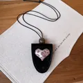 Detailansicht einer Leder-Brillenhalter-Halskette mit Herz im Leopardenmuster. - Schwarz