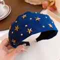 Macro view of a deep blue fabric headband featuring gold star studs and metallic accents - Headband-Blue