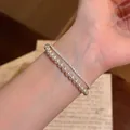 Detailansicht eines eleganten zweilagigen Perlenarmbands mit funkelnden Kristallen - Silber-Rosa