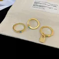 Detailed macro shot of vintage gold rings featuring vibrant zircons and a lock charm on a pouch - 3-Piece Ring Set (Gold) / Three-Piece Set