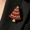 Detailansicht einer goldenen Weihnachtsbaumbrosche mit roten Kristallen an einem Anzug - Roter Strass-Weihnachtsbaum (10873)